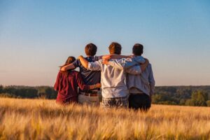 A group of friends in addiction recovery stands outside.