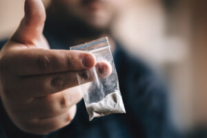 A person holds a bag of cocaine.